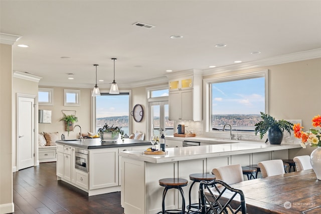 kitchen featuring sink, pendant lighting, white cabinets, and kitchen peninsula