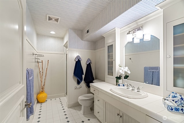 bathroom featuring walk in shower, tile patterned floors, vanity, and toilet