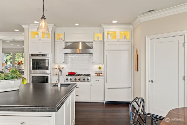 kitchen featuring decorative light fixtures, sink, white cabinets, stainless steel appliances, and wall chimney exhaust hood