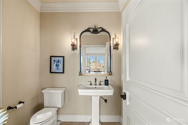 bathroom featuring crown molding and toilet