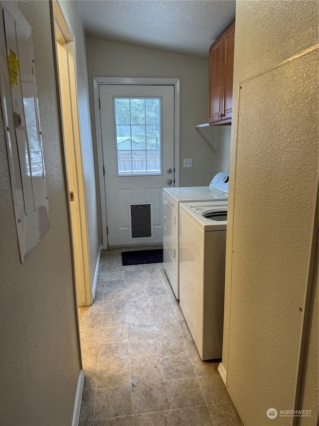 clothes washing area with cabinets, washer and clothes dryer, light tile patterned floors, electric panel, and a textured ceiling