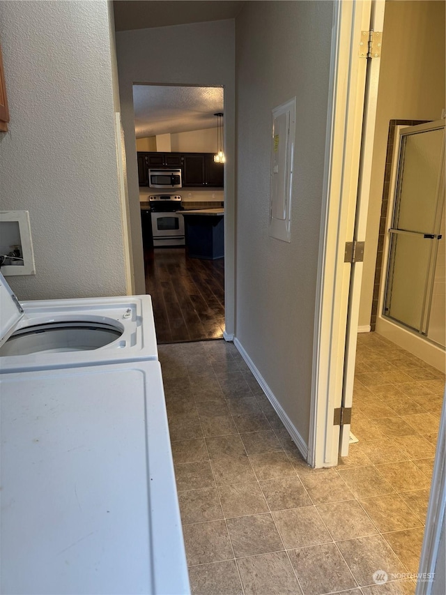 laundry room with electric panel and washer / dryer