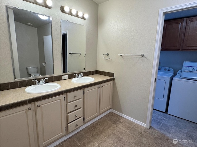 bathroom featuring independent washer and dryer, vanity, and toilet