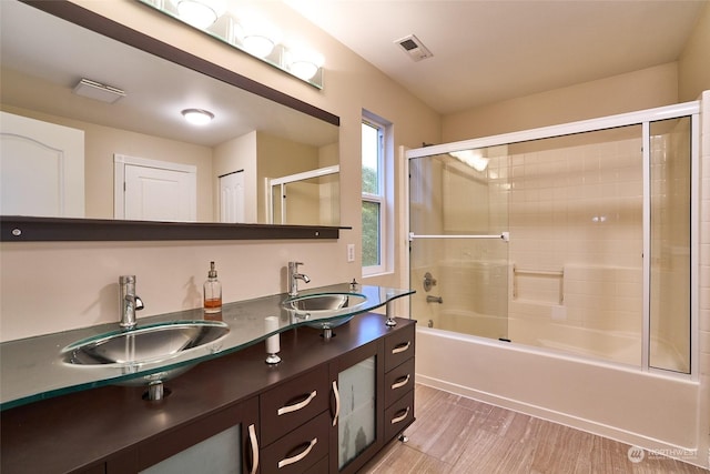 bathroom with vanity, shower / bath combination with glass door, and hardwood / wood-style floors