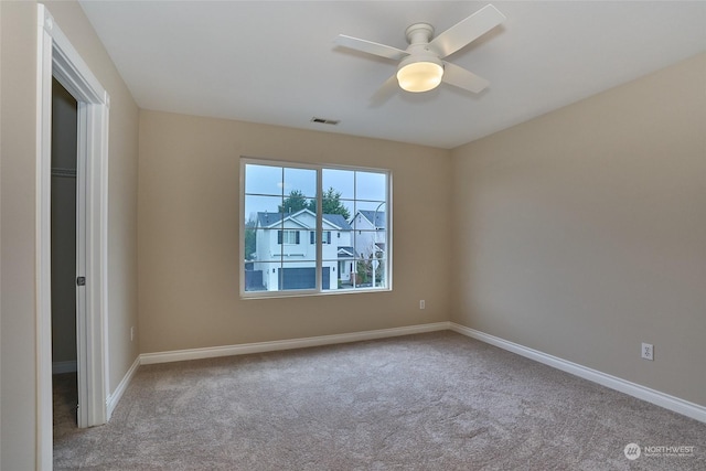 spare room featuring light carpet and ceiling fan