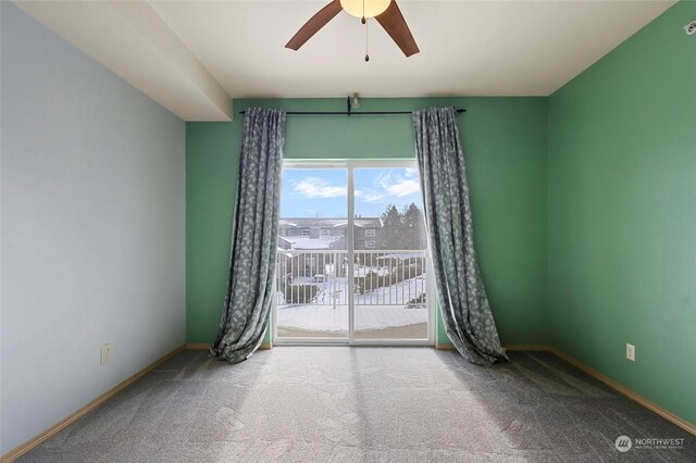 carpeted spare room featuring ceiling fan