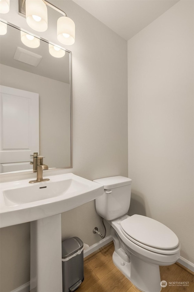 bathroom with sink, hardwood / wood-style flooring, and toilet