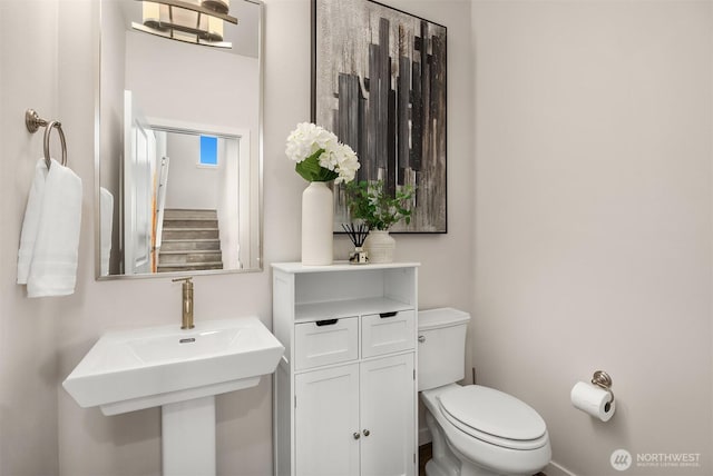 half bathroom featuring a sink and toilet