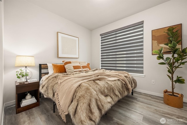 bedroom with baseboards and wood finished floors