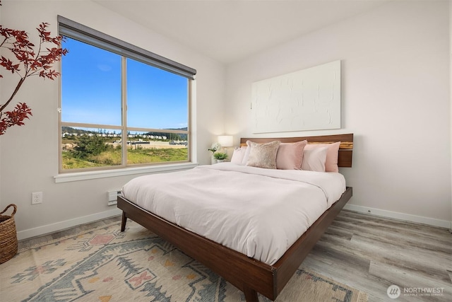 bedroom with wood finished floors and baseboards