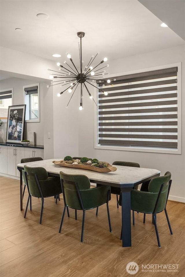 dining room featuring a chandelier and light wood-style flooring