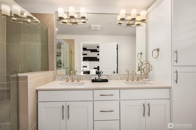 bathroom featuring double vanity, a stall shower, and a sink