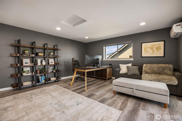 office area featuring attic access, baseboards, wood finished floors, a wall mounted air conditioner, and recessed lighting