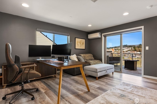 office area featuring recessed lighting, an AC wall unit, baseboards, and wood finished floors