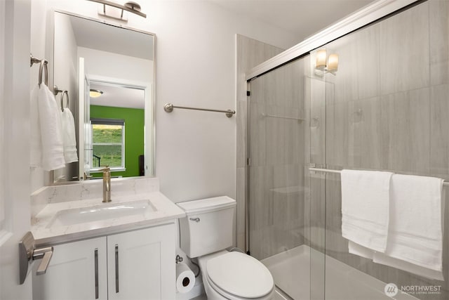 bathroom with toilet, a shower stall, and vanity