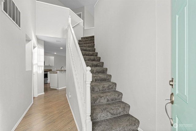 staircase with hardwood / wood-style flooring