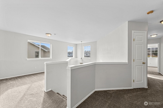 hallway featuring dark colored carpet