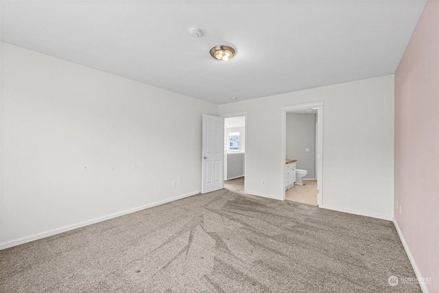 unfurnished bedroom featuring connected bathroom and light colored carpet