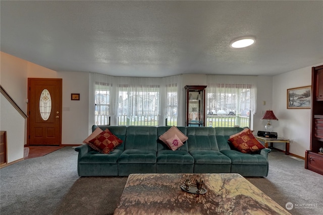 living room featuring dark carpet and a textured ceiling