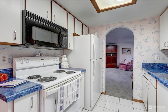 kitchen featuring white cabinetry, electric range, and light carpet