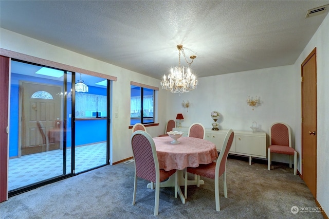 carpeted dining area featuring a textured ceiling and a chandelier