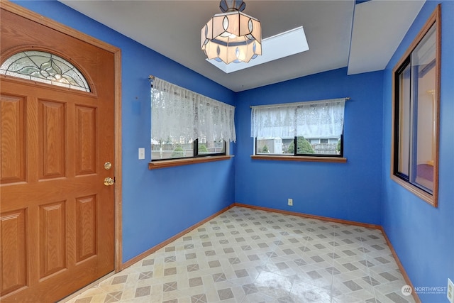 entrance foyer featuring vaulted ceiling with skylight