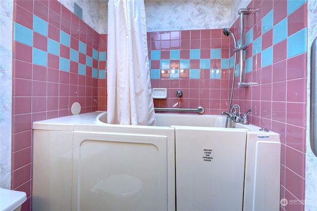 bathroom with tile walls and shower / bath combination with curtain