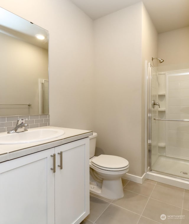 bathroom featuring a shower with door, tile patterned flooring, vanity, tasteful backsplash, and toilet