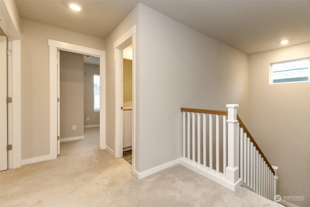 hallway featuring light colored carpet and a healthy amount of sunlight