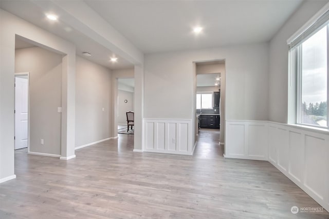 spare room featuring a wealth of natural light and light hardwood / wood-style floors