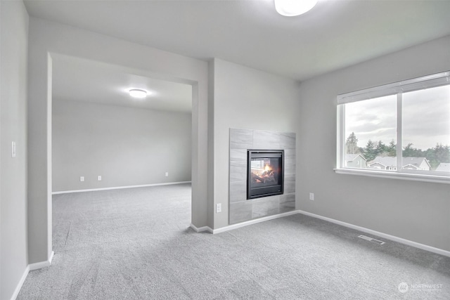 unfurnished living room featuring carpet and a fireplace