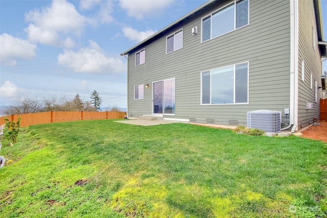 back of property with a yard, cooling unit, and a patio area