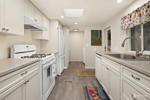 kitchen featuring dark hardwood / wood-style floors, white cabinetry, sink, and white appliances