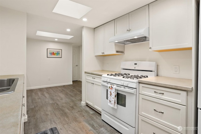 kitchen featuring white cabinetry, hardwood / wood-style flooring, a skylight, and gas range gas stove