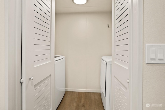 clothes washing area featuring wood-type flooring and independent washer and dryer