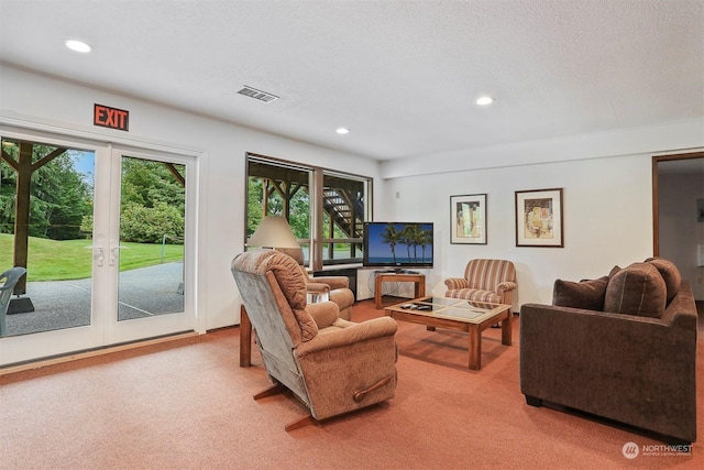 living room with carpet floors, french doors, and a textured ceiling