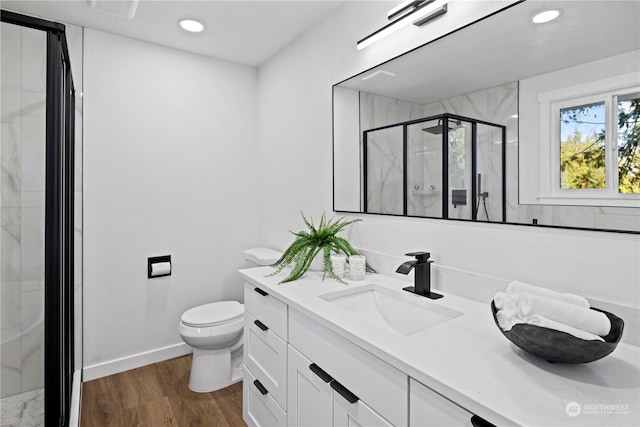 bathroom with wood-type flooring, toilet, vanity, and walk in shower