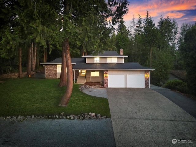 view of front facade with a yard and a garage