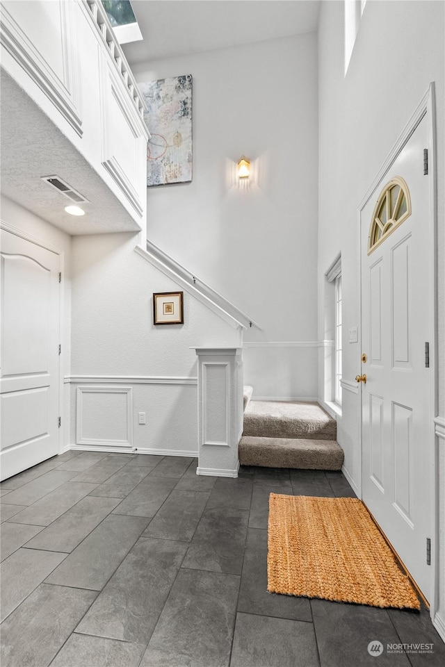 tiled entryway with a towering ceiling