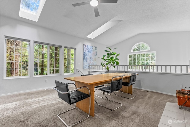 office with ceiling fan, lofted ceiling with skylight, light colored carpet, and a textured ceiling