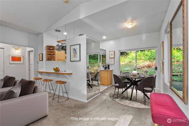 dining space featuring light carpet and lofted ceiling