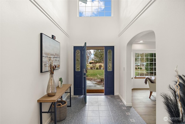 entryway featuring a towering ceiling and tile patterned floors