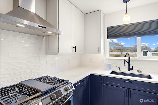 kitchen with sink, blue cabinetry, stainless steel gas stove, white cabinetry, and extractor fan