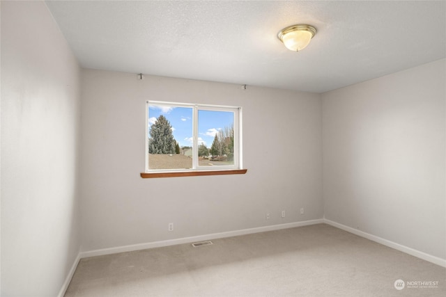 carpeted empty room featuring a textured ceiling