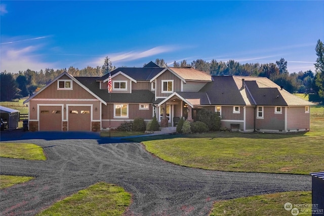 craftsman-style house featuring a garage and a lawn