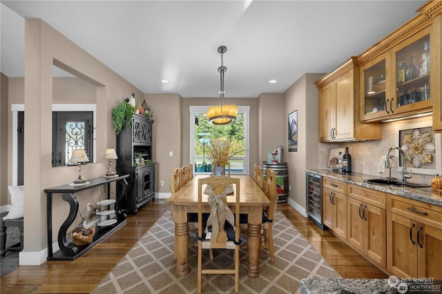 dining space featuring sink, dark hardwood / wood-style floors, and beverage cooler