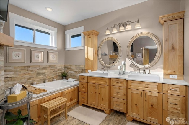 bathroom with hardwood / wood-style floors, vanity, and a bath