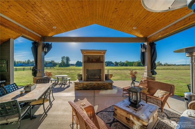 view of patio / terrace featuring a gazebo, a rural view, and exterior fireplace