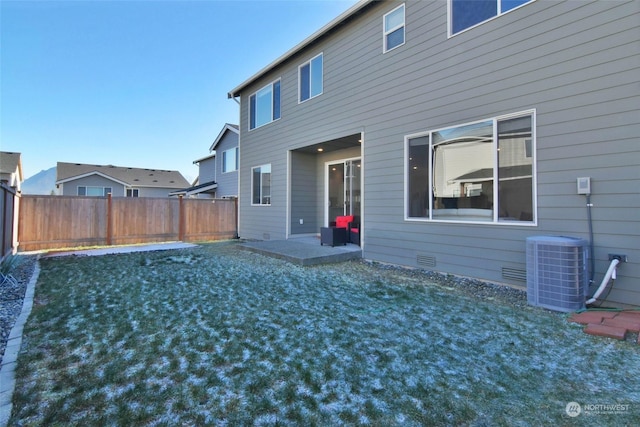 rear view of house featuring cooling unit, a yard, and a patio