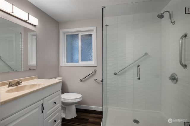 bathroom with an enclosed shower, vanity, hardwood / wood-style flooring, and toilet